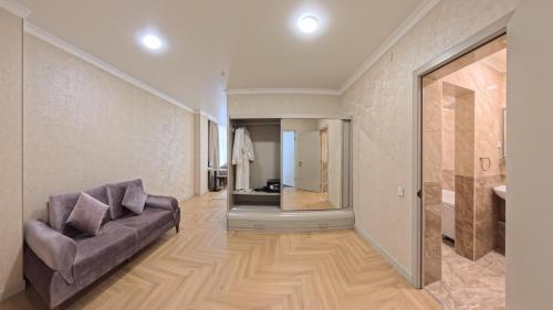 a living room with a couch and a mirror at Karagat Hotel in Karakol