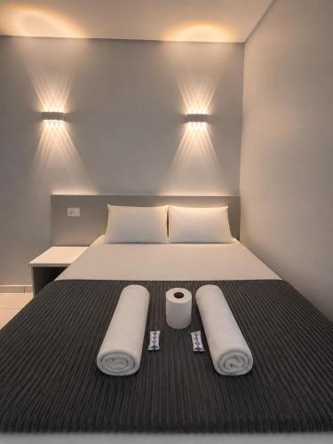 a bedroom with a bed with two towels on it at Hotel Colonial Plaza - Ao Lado do Metrô Armênia, 5 Min do Brás e Rua 25 de Março e 10 Min do Expo Pavilhões Anhembi in São Paulo