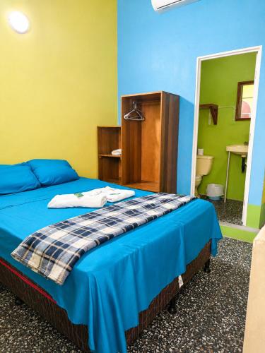 a bedroom with a bed with blue and yellow walls at Hospedaje doña Gladys in Flores