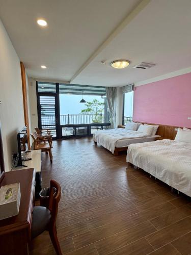 a hotel room with two beds and a pink wall at 傳說民宿 Legend in Fenqihu