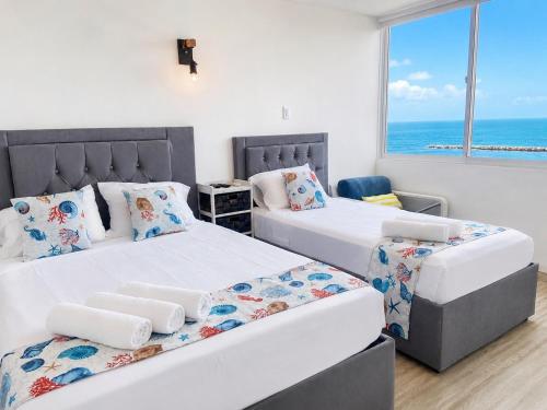 two beds in a bedroom with a view of the ocean at Getaway at Fragata Style with Ocean View in Cartagena de Indias