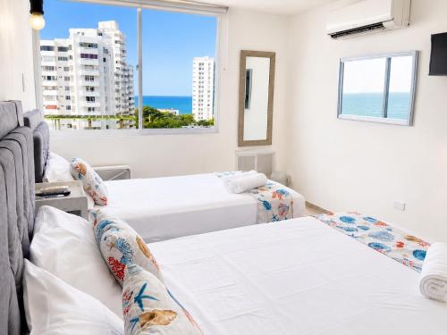 two beds in a room with a view of the ocean at Getaway at Fragata Style with Ocean View in Cartagena de Indias