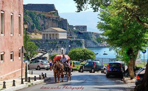 a horse drawn carriage on a city street near the ocean at Hebes Studios in Kavos