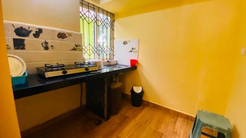 a bathroom with a sink and a counter with a window at Sevrina Beach Inn Calangute in Calangute
