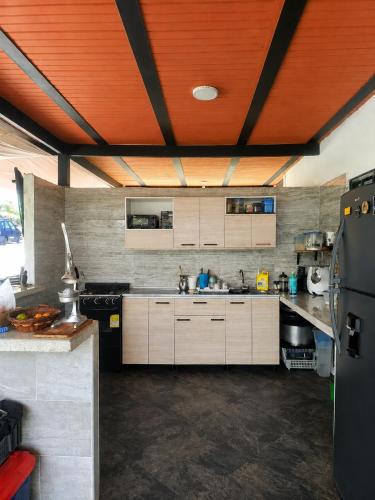 a kitchen with white cabinets and a wooden ceiling at Finca Cabañas el Higueron in Nocaima