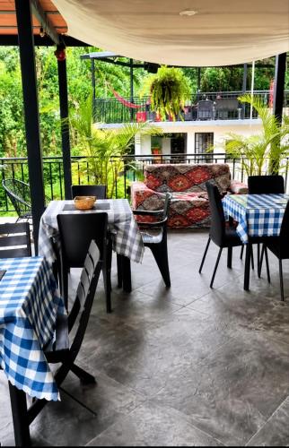 a patio with tables and chairs and a couch at Finca Cabañas el Higueron in Nocaima