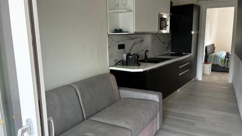 a living room with a couch and a kitchen at Pareti di mare in Capoliveri