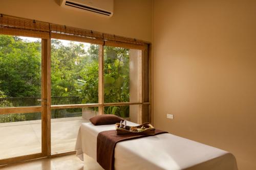 a bedroom with two beds and a large window at Hidden Secrets Dambulla in Dambulla