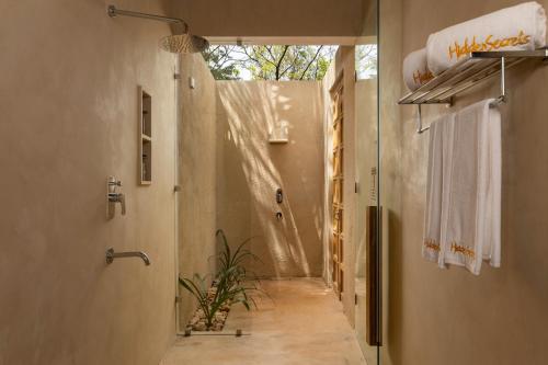 a bathroom with a walk in shower and a hallway at Hidden Secrets Dambulla in Dambulla