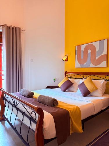a bedroom with a large bed with a yellow wall at White House Ella in Ella