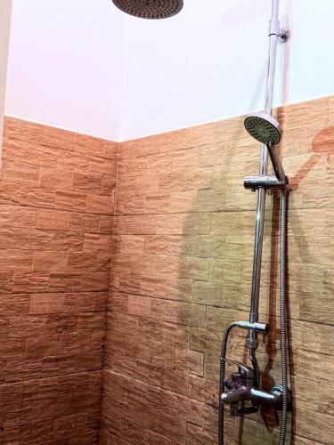 a shower in a bathroom with a brick wall at White House Ella in Ella