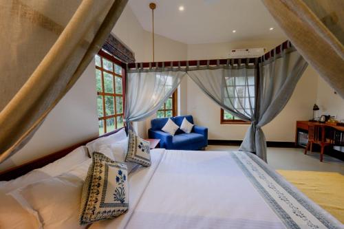 a bedroom with a bed and a blue chair at Nine Pines in Pīrmed