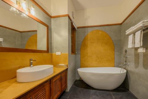 a bathroom with a white tub and a sink at Nine Pines in Pīrmed