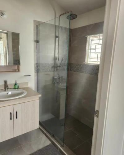 a bathroom with a shower and a sink at Deluxe Estate in Portmore