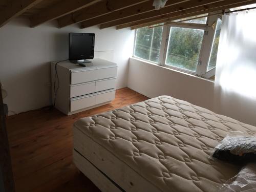1 dormitorio con cama y vestidor con TV en Vistalmar Alfar, en Mar del Plata