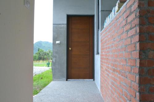 uma porta numa parede de tijolos ao lado de um edifício em David SamStrong Villa 大尾山姆維拉 em Chenggong