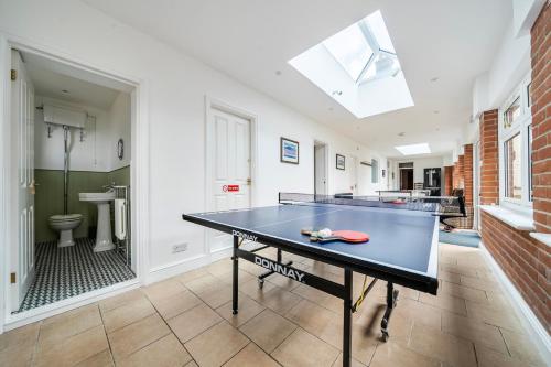 a ping pong table in a room with a bathroom at High House in Norwich