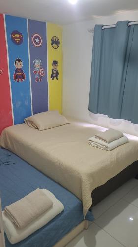 a bedroom with a large bed with a blue curtain at Joy Apartamento completo in Salvador
