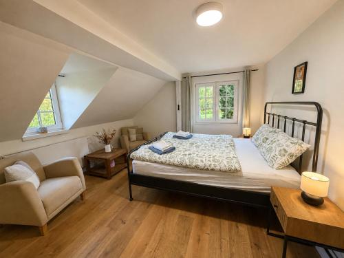 a bedroom with a bed and a chair at Wellness Chalet Luby in Luby