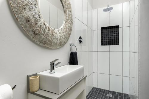 a white bathroom with a sink and a mirror at Ukholo Lodge in Citrusdal