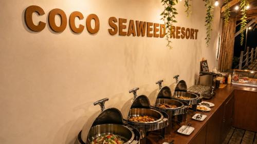 a row of bowls of food on a counter in a restaurant at Coco Seaweed Resort in Semporna