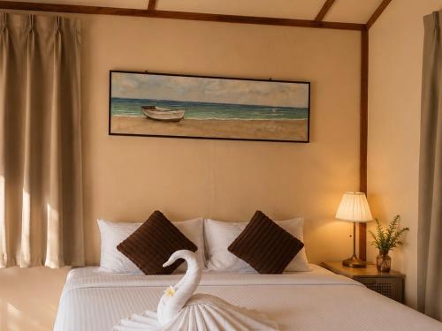 a bedroom with two beds with a swan on them at Coco Seaweed Resort in Semporna