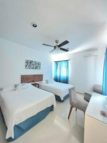 a hotel room with two beds and a chair at Casa Terracota Micro Hotel Consulado in Mérida