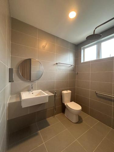 a bathroom with a toilet and a sink and a mirror at Haus176 in Bentong
