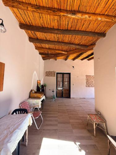a large room with a wooden ceiling and chairs at Casa de Adobe Doña Tinogasta in Tinogasta