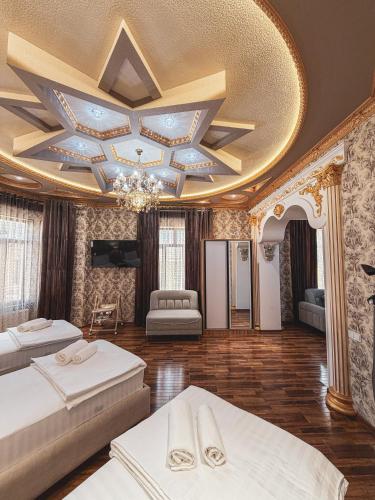 a large room with two beds and a ceiling at As-Mira Hotel in Samarkand