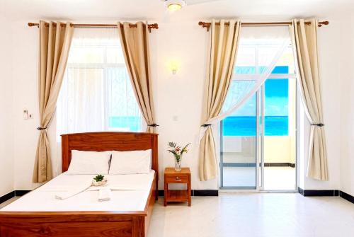 a bedroom with a bed with a view of the ocean at Ocean-View Balcony - Uroa 2 bedroom Beachfront apt in Uroa