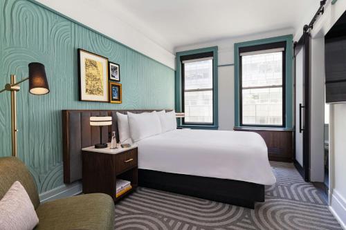a hotel room with a bed and a chair at The Algonquin Hotel Times Square, Autograph Collection in New York