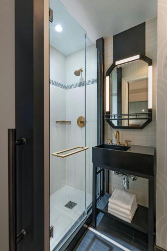 a bathroom with a glass shower and a sink at The Algonquin Hotel Times Square, Autograph Collection in New York