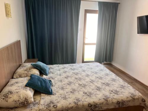 a bedroom with two beds and a window at CAZARE JASMINA in Corbu