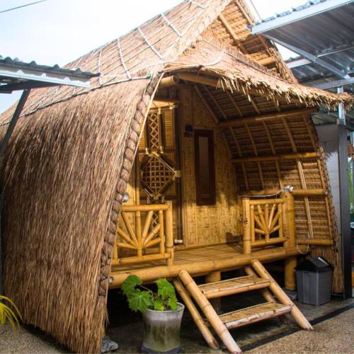 a small hut with a thatched roof at The Twins Sunset Bungalow in Ekas
