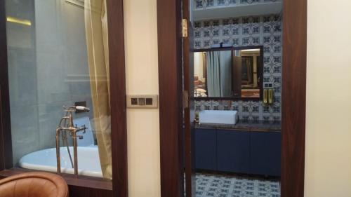 a bathroom with a tub and a sink and a mirror at Parinay Pavilion LLP in Bahraich
