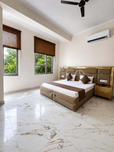 a bedroom with a large bed and a ceiling fan at Hotel Swisston Palace in New Delhi