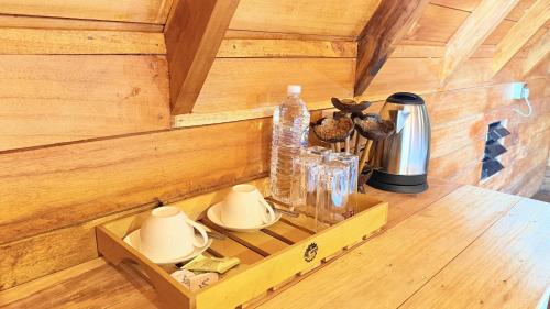 a wooden cabin with a shelf with dishes and bottles at Nature Bliss Ella in Ella