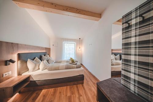 a bedroom with a large bed and a window at Historic Residence Barbara in Colle Isarco