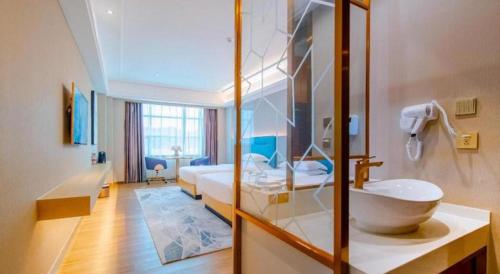 a bathroom with a sink and a bed and a tub at Cheermay Hotels in Dongguan