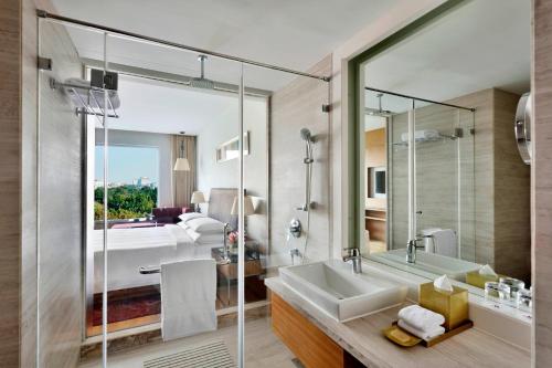 ein Badezimmer mit Badewanne, Waschbecken und Bett in der Unterkunft Indore Marriott Hotel in Indore
