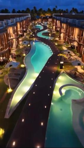 an overhead view of a pool at a resort at night at Naay Villas - Flat Beira Mar - Sao Miguel dos Milagres in Pôrto de Pedras