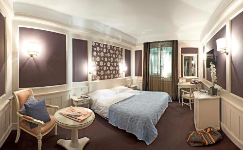 um quarto de hotel com uma cama, uma mesa e cadeiras em Europa Hotel Design Spa 1877 em Rapallo