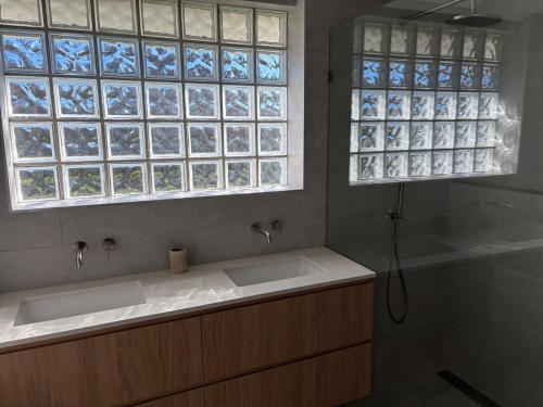 a bathroom with two sinks and two windows at Tiberius House in Saint Andrews Beach