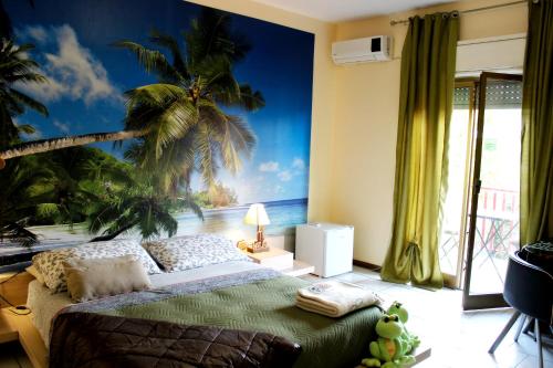 a bedroom with a mural of a palm tree at B&B Santa Sofia in Gravina di Catania