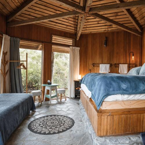 a bedroom with a large bed and a table at Ora Retreat in Queenstown