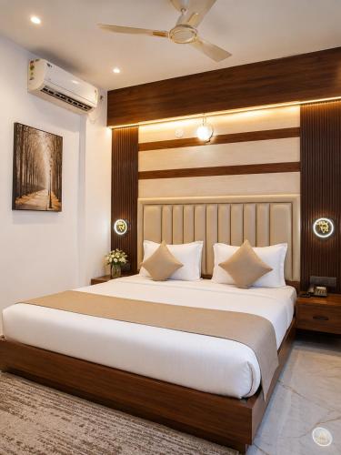 a bedroom with a large bed with white pillows at Orange Elite Stays Whitefield in Bangalore