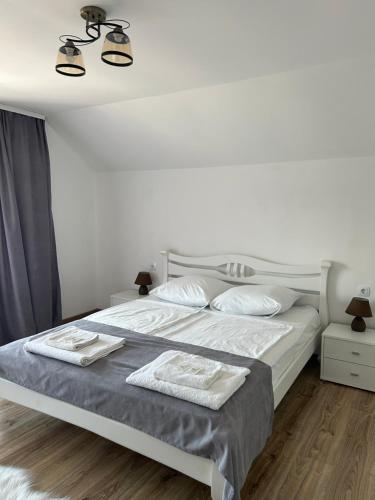 a white bedroom with a bed with two towels on it at Anamyra in Mizhhirya