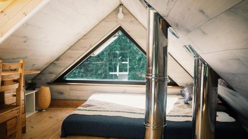 a bedroom with a bed and a window in a attic at Härjamäe Saunamaja 