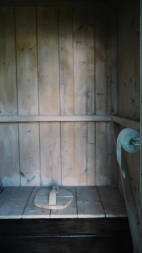 a bathroom with a toilet in a wooden wall at Härjamäe Saunamaja 